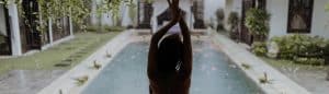 Donna che si rilassa in una piscina all'aperto con giardino curato.