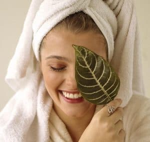 Donna con asciugamano e foglia, benessere naturale, relax.