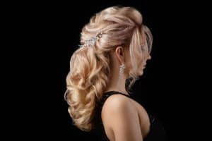 Acconciatura elegante con riccioli e accessori per capelli, perfetta per occasioni speciali.