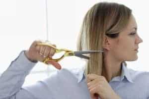 Taglio di capelli donna professionale con forbici dorate.