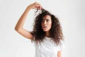 Donna con capelli ricci e confusi, espressione di incertezza.