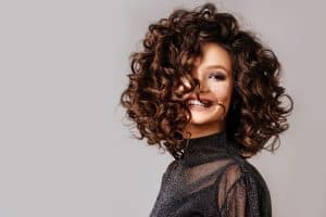 Capelli ricci e voluminosi con lucentezza naturale, perfetti per ogni occasione.