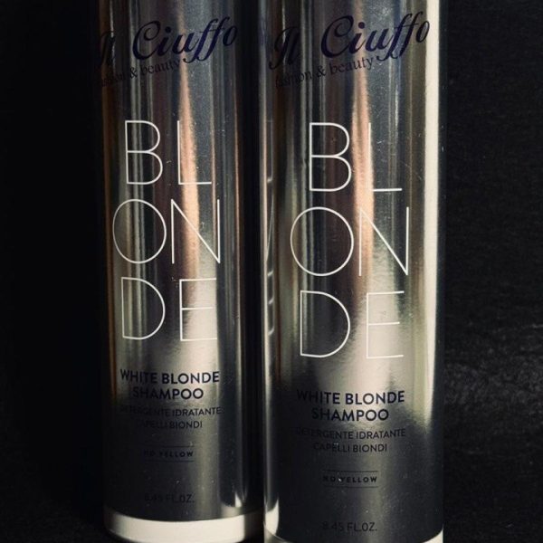 Shampoo biondo bianco in bottiglia con etichetta nera e bianca.