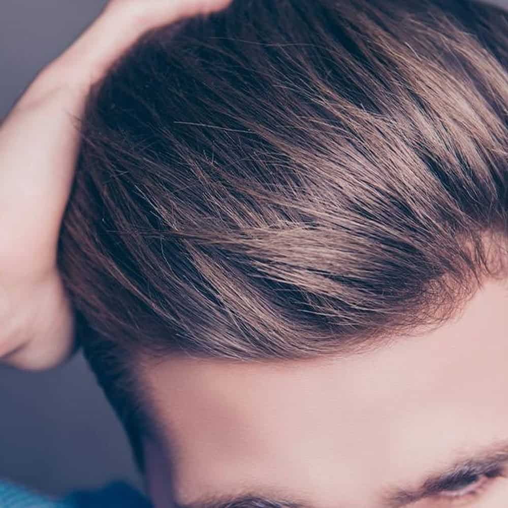 Pettinatura elegante con capelli castani lucidi, stile moderno e curato. Perfetta per occasioni form.