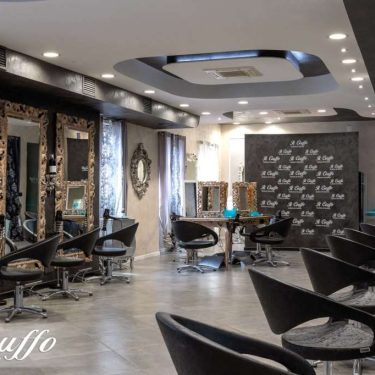 Camerino di bellezza con specchi, sedie e illuminazione moderna, ideale per trattamenti di bellezza.