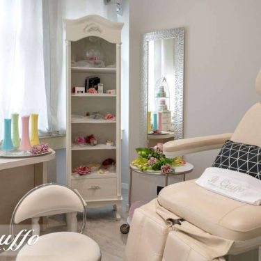 Camerino estetico con poltrona e attrezzature per trattamenti di bellezza.
