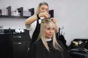 Taglio capelli professionale in salone di bellezza, stylist al lavoro.