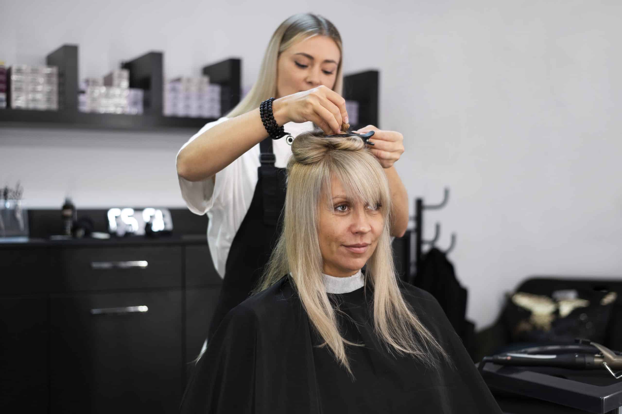 Taglio capelli professionale in salone di bellezza, stylist al lavoro.