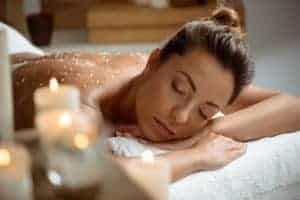 Donna che riceve un massaggio rilassante con candele accese.