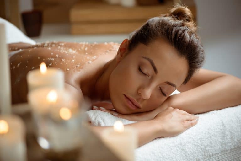 Donna che riceve un massaggio rilassante con candele accese.