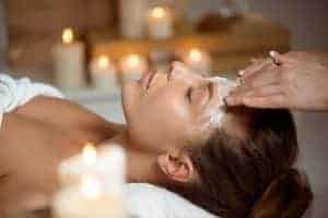 Trattamento di bellezza con massaggio facciale e candele calde.