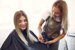 Donna che riceve un taglio di capelli da un parrucchiere professionista.