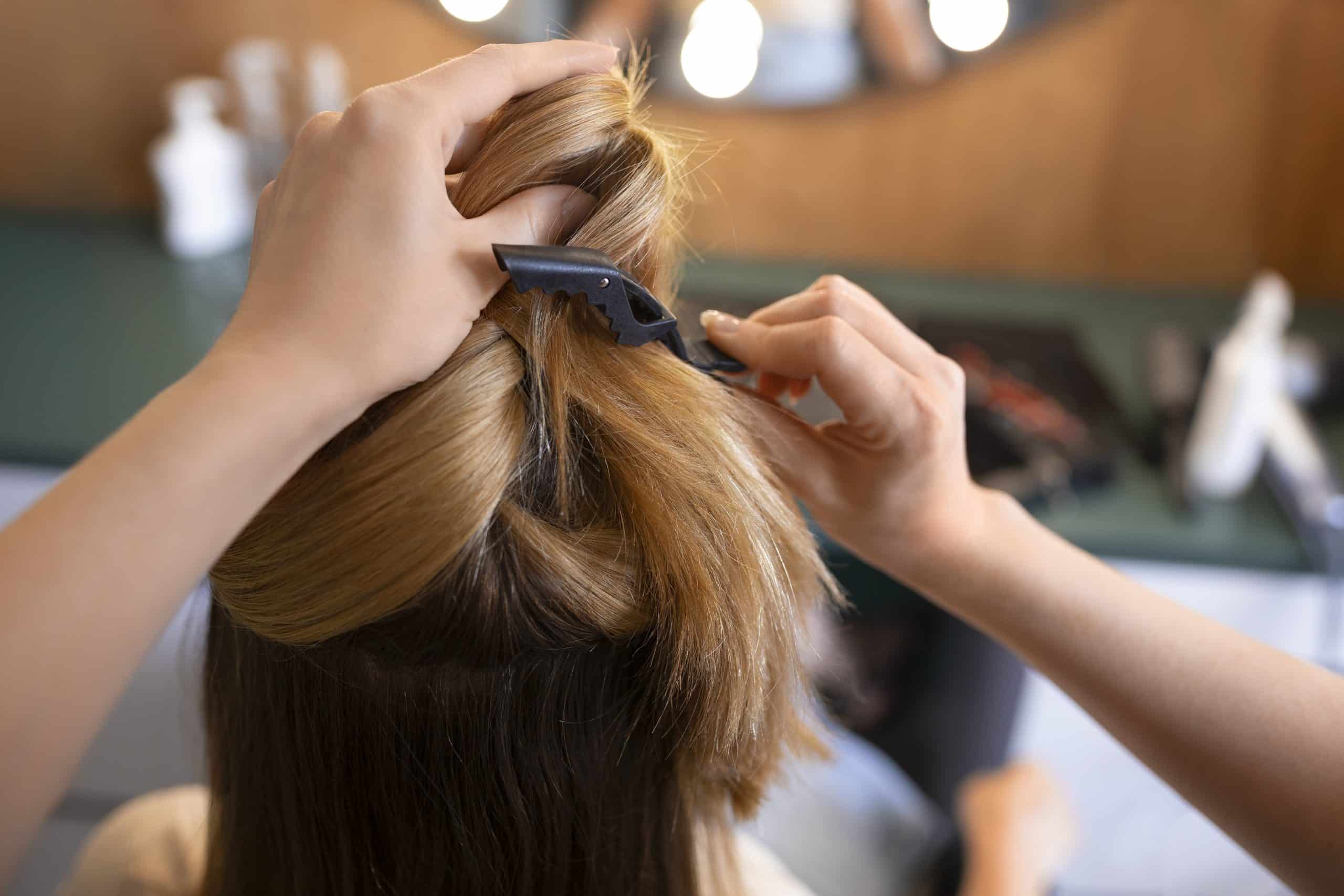 Tecnico che realizza un taglio di capelli con forbici e pettine in salone di bellezza.